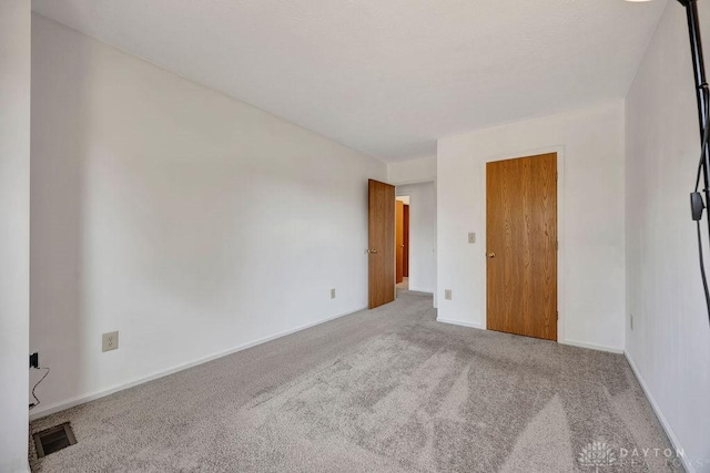 unfurnished bedroom with baseboards, visible vents, and carpet floors