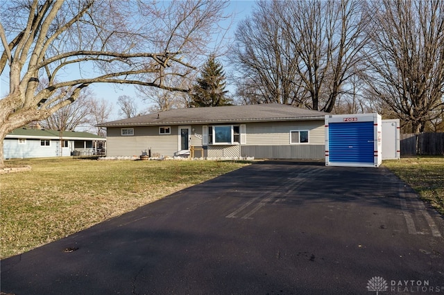 ranch-style house with a front yard, driveway, and fence