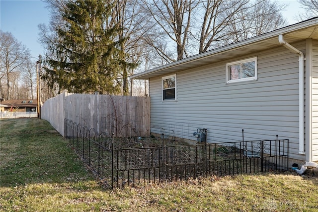 view of side of property with a lawn and fence