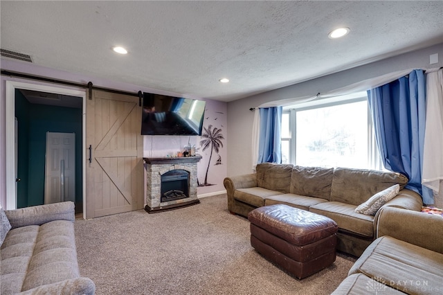 living room with visible vents, carpet floors, recessed lighting, a textured ceiling, and a barn door