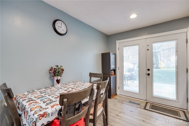 dining room featuring french doors and light wood finished floors