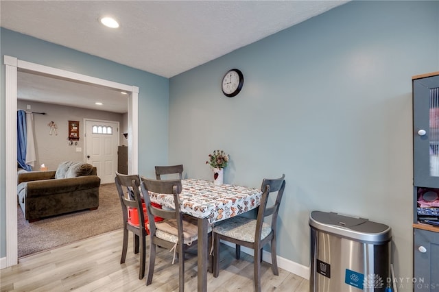 dining room featuring recessed lighting, baseboards, light wood finished floors, and a textured ceiling