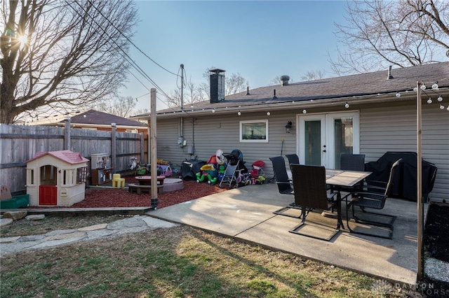 rear view of house featuring a patio area, fence, french doors, and a chimney