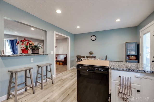 kitchen featuring a textured ceiling, black dishwasher, white cabinetry, recessed lighting, and light wood-style floors