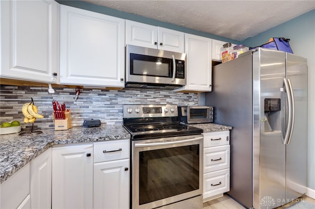 kitchen featuring tasteful backsplash, appliances with stainless steel finishes, and white cabinetry