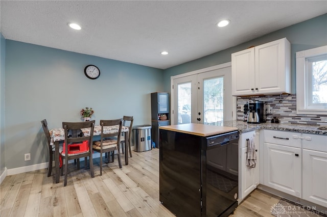 kitchen featuring white cabinets, plenty of natural light, tasteful backsplash, and light wood finished floors