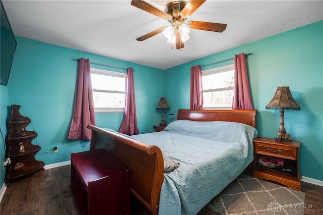 bedroom featuring baseboards, multiple windows, and wood finished floors