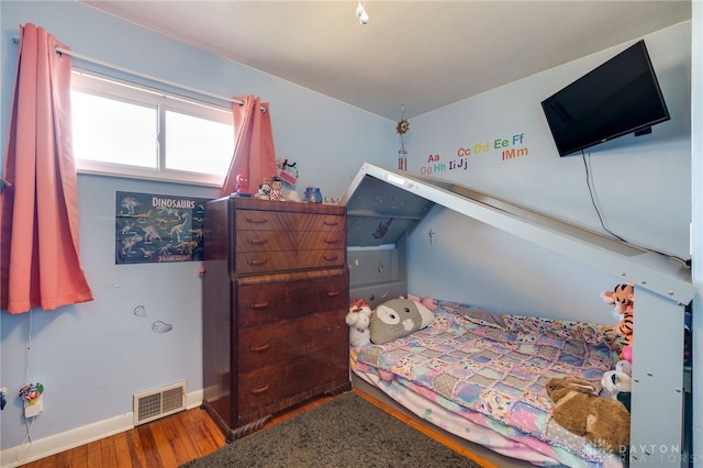 bedroom featuring visible vents, baseboards, and wood finished floors