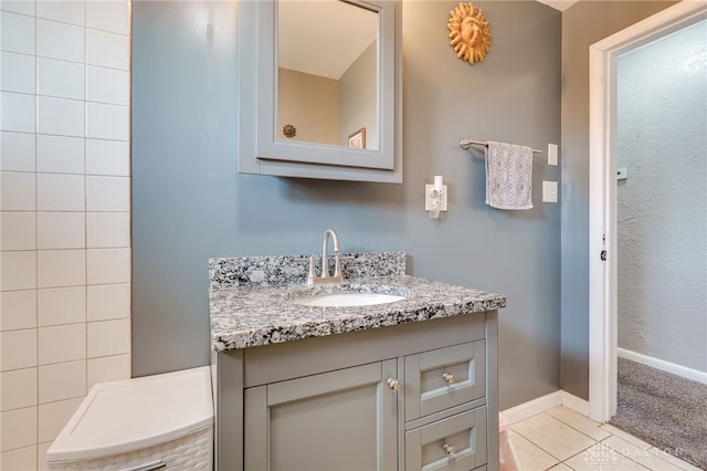 bathroom featuring tile patterned floors, baseboards, and vanity