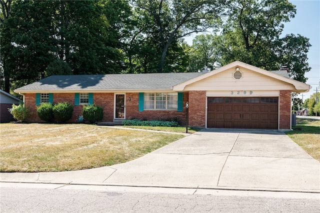 single story home featuring brick siding, a garage, driveway, and a front yard