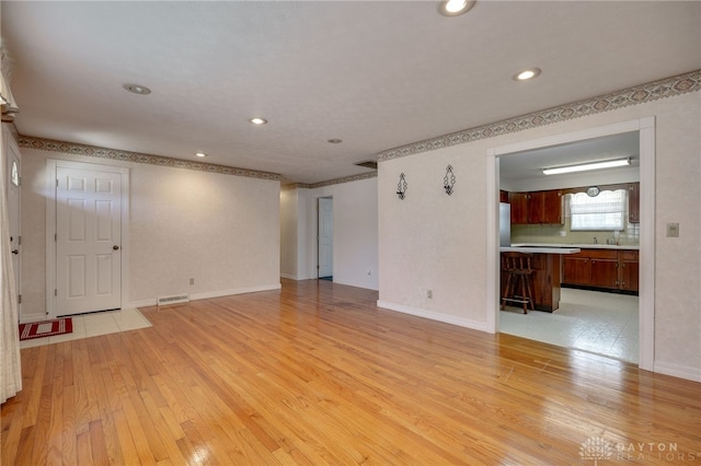 unfurnished living room featuring recessed lighting, visible vents, baseboards, and light wood-style flooring