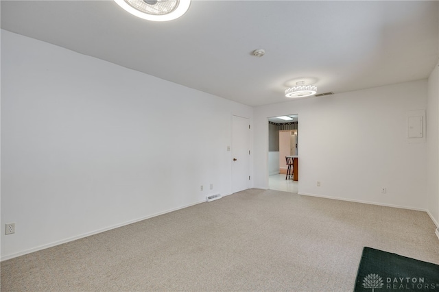 carpeted spare room with visible vents and baseboards