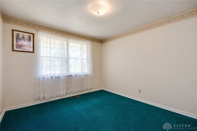 unfurnished room with carpet, visible vents, and baseboards