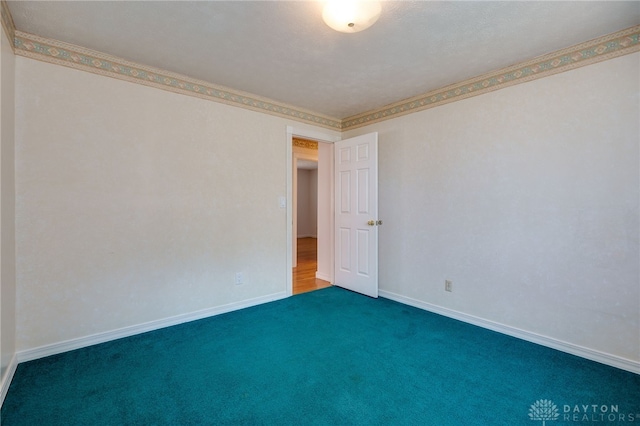 unfurnished room with carpet and baseboards