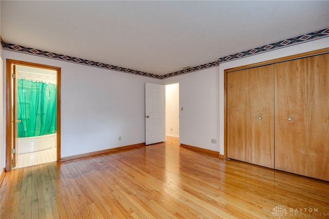 unfurnished bedroom with light wood-style floors, baseboards, and a closet