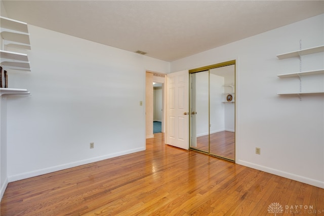 unfurnished bedroom with visible vents, baseboards, and light wood-style floors