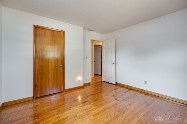 unfurnished bedroom with baseboards and light wood-style floors