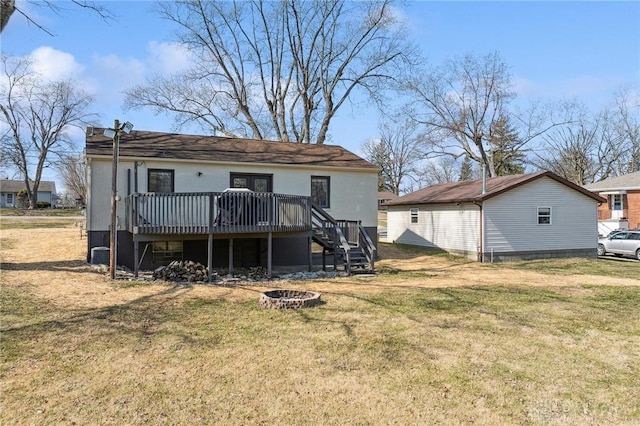 rear view of property with a wooden deck, a yard, stairway, and an outdoor fire pit