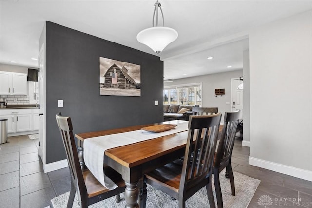 dining room featuring recessed lighting, baseboards, and dark tile patterned floors