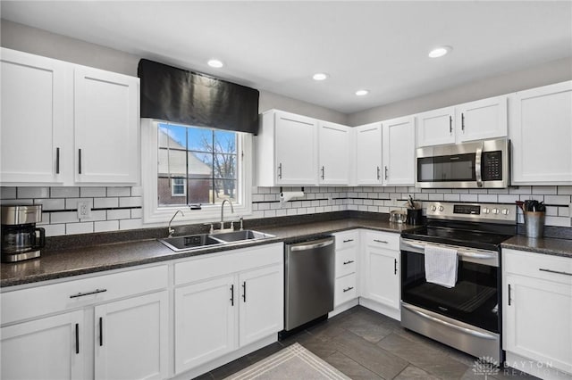 kitchen featuring tasteful backsplash, appliances with stainless steel finishes, white cabinetry, and a sink