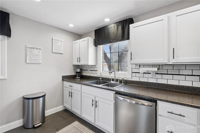 kitchen featuring a sink, backsplash, stainless steel dishwasher, dark countertops, and white cabinetry