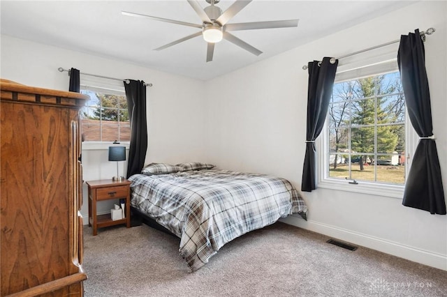 carpeted bedroom featuring visible vents, baseboards, and ceiling fan