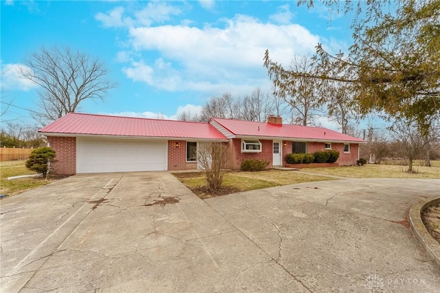 single story home with brick siding, an attached garage, a front lawn, metal roof, and driveway