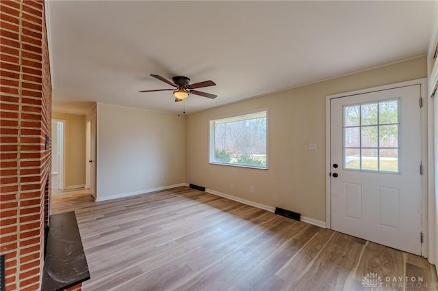 interior space featuring light wood-style floors, baseboards, and ceiling fan