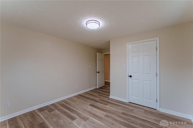 unfurnished bedroom featuring baseboards and light wood-style floors