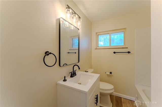 full bath featuring baseboards, toilet, wood finished floors, and vanity