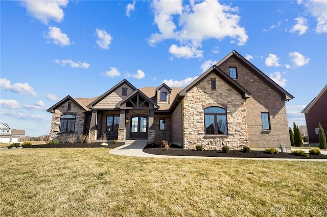 view of front of house featuring stone siding, french doors, and a front lawn