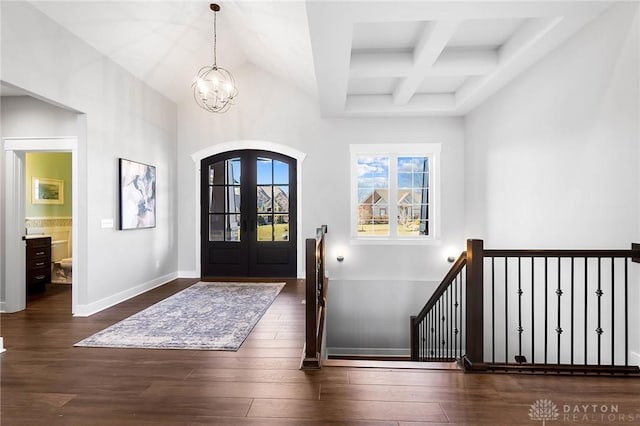 entrance foyer with wood finished floors, baseboards, coffered ceiling, beamed ceiling, and a notable chandelier