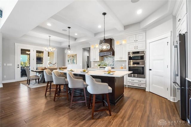 kitchen featuring appliances with stainless steel finishes, dark wood finished floors, light countertops, and custom range hood