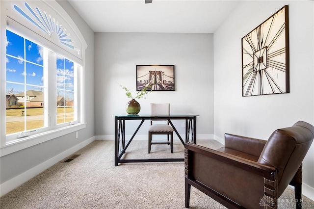 carpeted office space featuring visible vents and baseboards