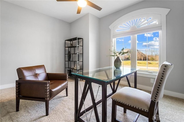 carpeted home office featuring baseboards and ceiling fan