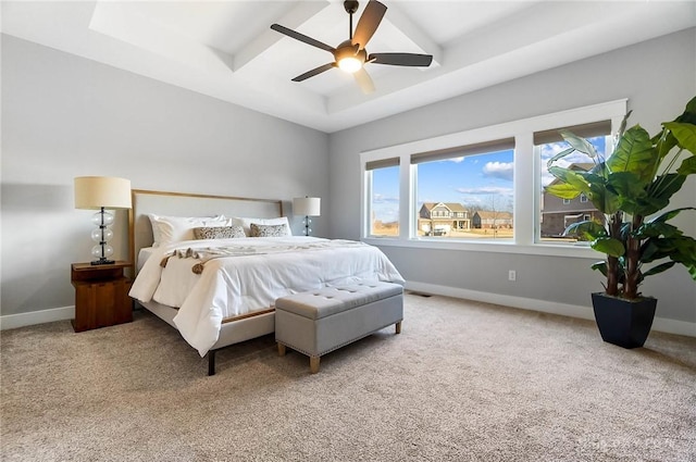 carpeted bedroom featuring a raised ceiling, a ceiling fan, and baseboards