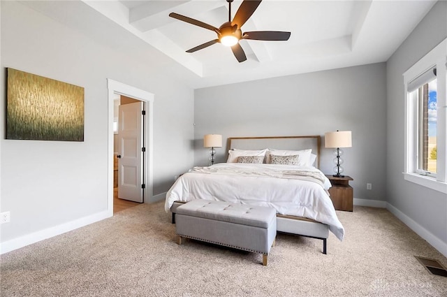 bedroom with visible vents, baseboards, a tray ceiling, carpet flooring, and a ceiling fan