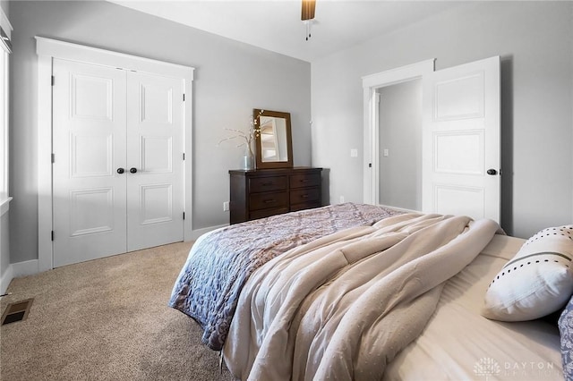 carpeted bedroom featuring a closet, visible vents, and a ceiling fan