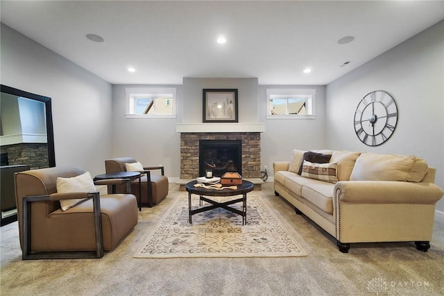 living area with recessed lighting, baseboards, light carpet, and a glass covered fireplace