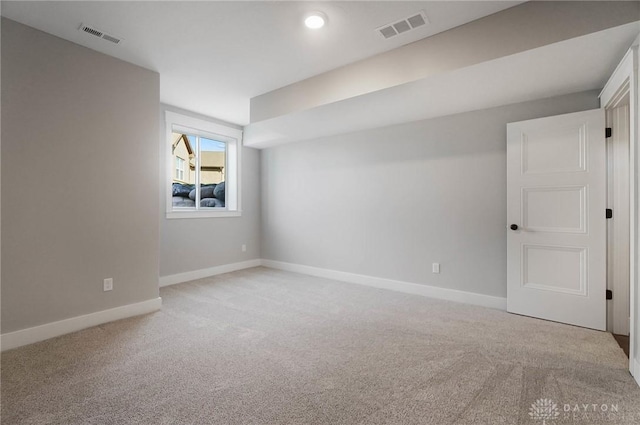 spare room featuring visible vents, baseboards, and light colored carpet