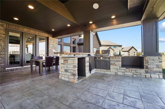 view of patio featuring outdoor wet bar, area for grilling, and exterior kitchen