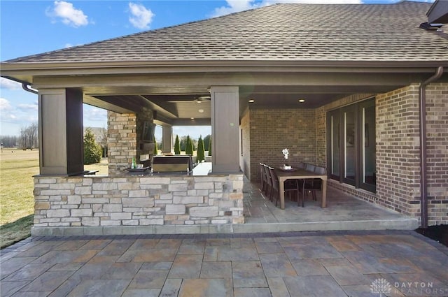 view of patio / terrace with outdoor dry bar, an outdoor kitchen, and outdoor dining area