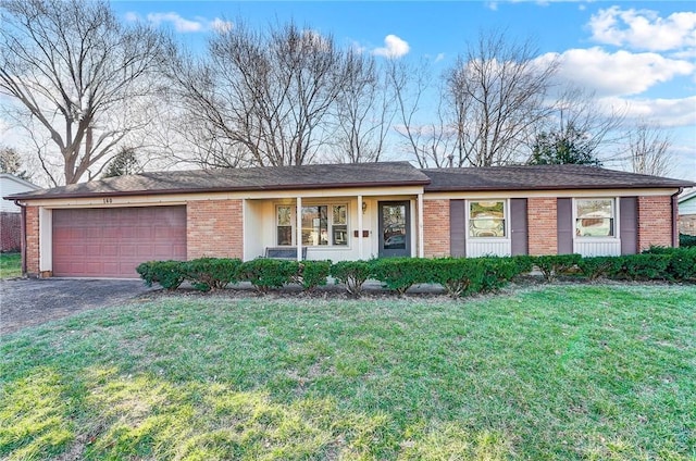 single story home with brick siding, a garage, driveway, and a front lawn