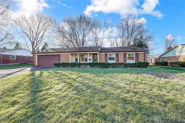 view of front facade with driveway, brick siding, an attached garage, and a front lawn