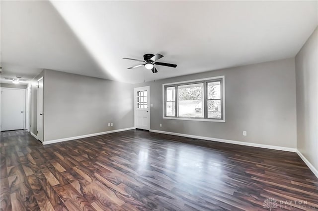 unfurnished living room featuring baseboards, dark wood finished floors, and a ceiling fan