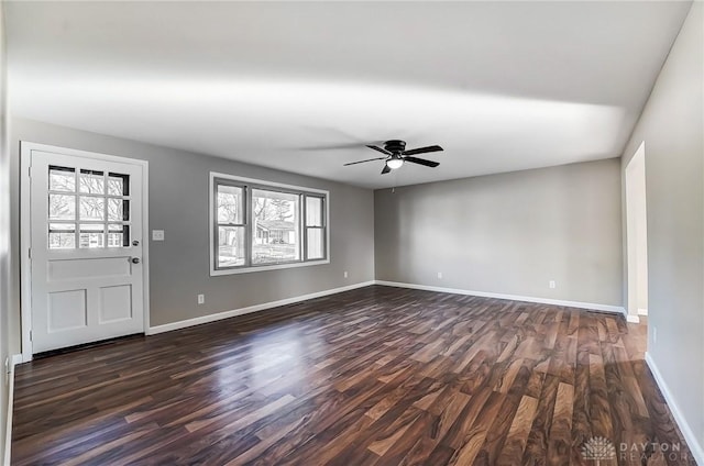 interior space featuring ceiling fan, dark wood-type flooring, and baseboards