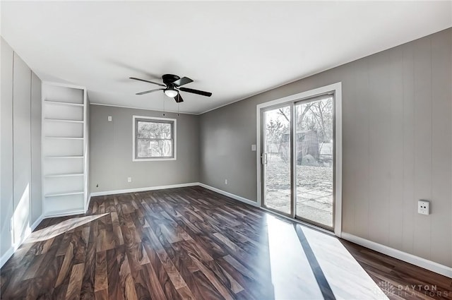 unfurnished room with a healthy amount of sunlight, ceiling fan, and dark wood-style flooring