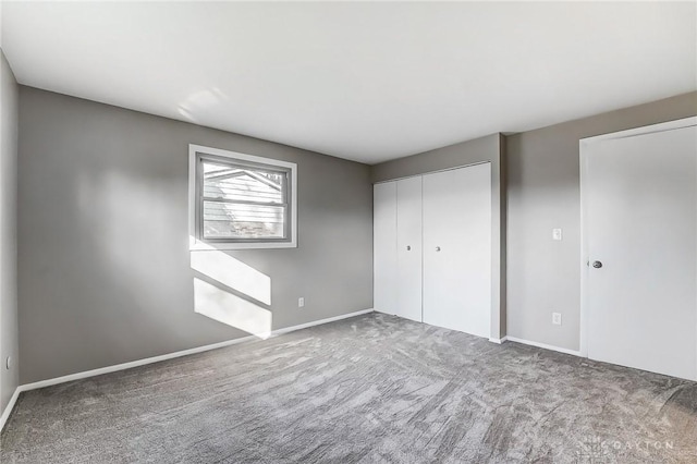 unfurnished bedroom featuring a closet, baseboards, and carpet