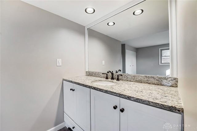 bathroom with vanity, recessed lighting, and baseboards