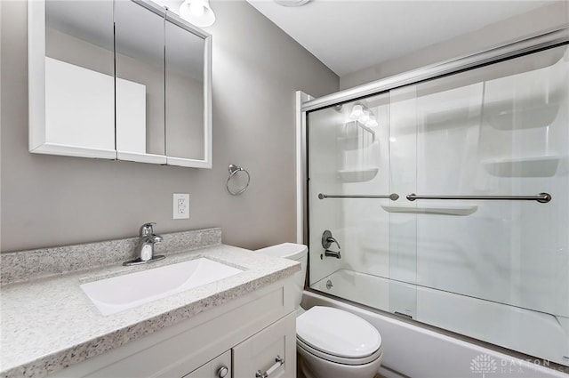 full bathroom with enclosed tub / shower combo, toilet, and vanity